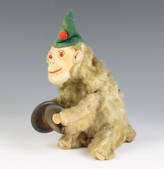 A clockwork figure of a monkey with cymbals, the ear by the paper ticket marked MC Original 