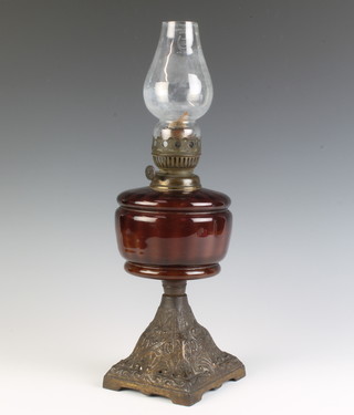 A Victorian oil lamp with glass reservoir raised on a pierced iron base 43cm x 11cm x 12cm 