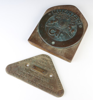 A circular bronze plaque decorated the Royal Arms marked Mukhtar G.R 16cm and a triangular cast iron plaque marked Type GMK distributor Nicholsons New Market England 