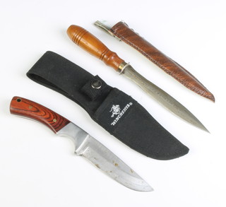 A Winchester hunting knife with 4cm blade, grained wooden grip, complete with cloth scabbard and an Eastern double bladed dagger with turned handle and leather finished scabbard 13cm 