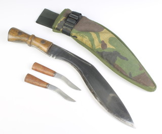 A military issue Kukri with 31cm blade, the grip marked 4 with crows foot mark 27 70 together with 2 skinning knives contained in a leather and camouflage scabbard