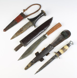 A double bladed dagger with 40cm blade and horn grip, complete with leather scabbard together with an Eastern double bladed dagger with 15cm blade, wooden grip and leather scabbard, an Arabic knife with 20cm blade and leather finished scabbard
