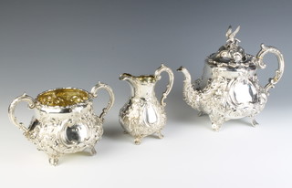 A Victorian repousse silver tea set comprising teapot, 2 handled sugar bowl and milk jug with floral decoration and vacant cartouche on scroll feet, London 1866, maker Charles Boyton, 1585 grams 