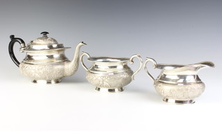 An Indian repousse silver tea set comprising teapot, milk jug and sugar bowl decorated with figures and animals before buildings in forest settings, gross weight 1395 grams