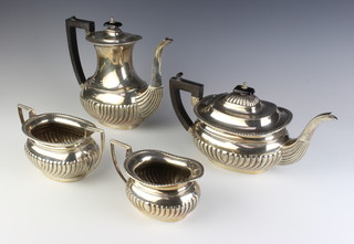 A 4 piece repousse silver tea and coffee set with demi-fluted decoration and ebony mounts, 1680 grams gross 
