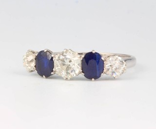 A platinum 3 stone diamond and 2 stone sapphire ring, the diamonds approx 0.3, 0.7 and 0.3 carat, the sapphires each 0.5 carat, size Q