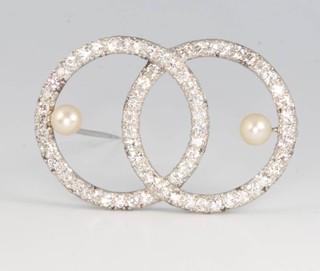 An Art Deco style brilliant cut diamond and pearl brooch with 2 interlocking circles 