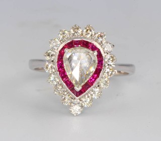 An 18ct white gold pear cut diamond and ruby ring, the centre stone approx. 0.56ct surrounded by caliber cut rubies approx 0.7ct and brilliant cut diamonds approx. 0.57ct size M 