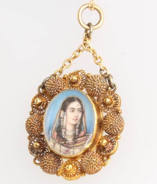 An Indian gold pendant with a painted portrait miniature of a lady on a gilt chain 