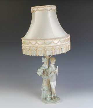A Lladro table lamp in the form of a boy with a dove on his hand standing beside a tree 31cm 
