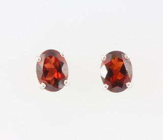 A pair of silver and garnet ear studs 