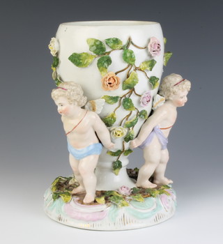 A German porcelain porcelain centrepiece with 3 angels supporting an ovoid vase applied with flowers 24cm 