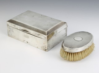A rectangular silver engine turned cigarette box London 1927 14cm by 5cm by 9cm a silver hair brush and a ewer with plated stopper