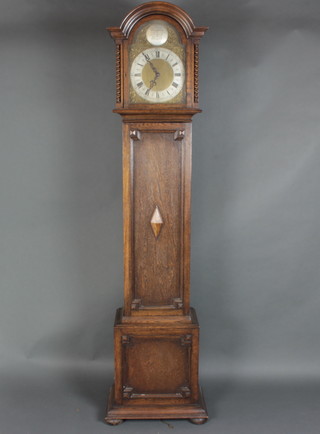 A 1930's chiming longcase clock with 27cm arched brass dial, silvered chapter ring with Roman numerals, contained in an oak case with sliding hood and geometric mouldings, raised on bun feet 194cm x 39cm x 26cm 