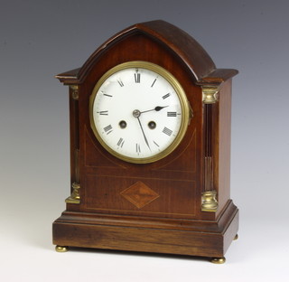 A French 19th Century 8 day striking mantel clock with enamelled dial and Roman numerals contained in an inlaid mahogany lancet style case 