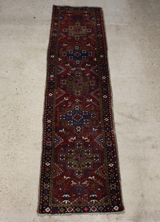 A brown and green ground Persian Garajhe runner with 5 stylised medallions to the centre 322cm x 83cm 
