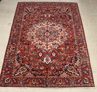 A red and blue ground floral patterned Bakhtiari carpet with central medallion with a 3 row border 310cm x 215cm 