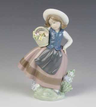 A Lladro figure of a girl holding a basket of flowers 16cm 