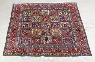 A floral patterned Persian carpet, the centre formed of 25 square panels with floral decoration 187cm x 207cm 