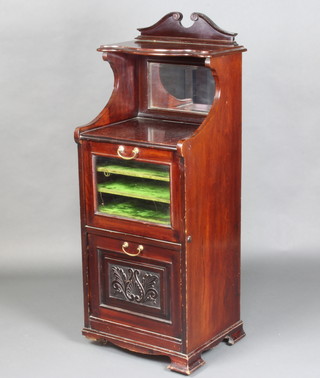 An Edwardian carved mahogany music cabinet, the upper section with broken pediment above a recess, fitted shelves enclosed by a glazed panelled door, the lower section fitted a music purdonium, raised on ogee bracket feet 121cm h x 46cm w x 39cm d 