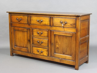 A 17th/18th Century style elm dresser base fitted 3 long drawers above 3 short drawers flanked by a pair of cupboards with swan neck drop handles 87cm h x 154cm w x 46cm d 