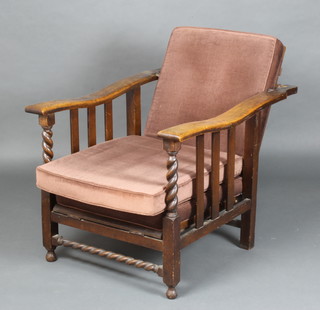 A 1930's oak reclining armchair with spiral turned decoration, the seat and back upholstered in brown Dralon 