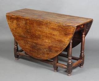 An 18th Century oval oak drop flap gateleg dining table fitted a drawer, raised on turned supports 72cm h x 122cm w x 41cm when closed x 153cm when open 