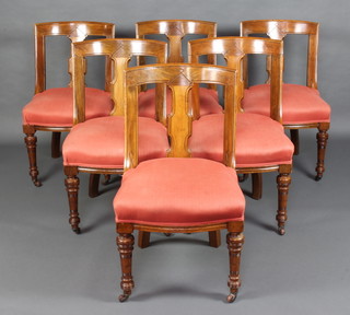 A set of 6 Victorian mahogany slat and rail back dining chairs with over stuffed seats, raised on turned supports 