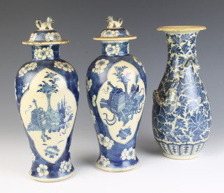 A Chinese blue and white oviform vase decorated with dragons on a field of flowers 25cm and a pair of prunus  baluster vases and covers decorated with flowers having lion finials 28cm (both lids are chipped) 