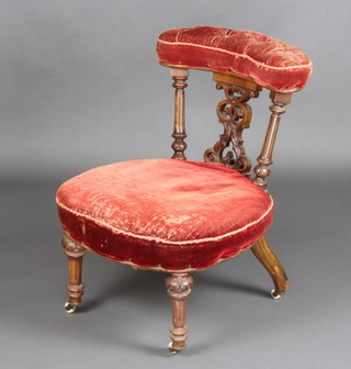 A Victorian walnut nursing chair with pierced vase shaped slat back, upholstered in velvet, raised on turned and fluted supports (velvet is worn)
