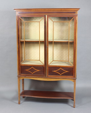 An Edwardian inlaid mahogany display cabinet, fitted shelves enclosed by astragal glazed panelled doors, raised on square tapered supports with under tier, ending in spade feet 174cm h x 112cm w x 38cm d  