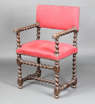 A Carolean style oak open arm chair with lion mask decoration, raised on spiral turned and block supports with H framed stretcher