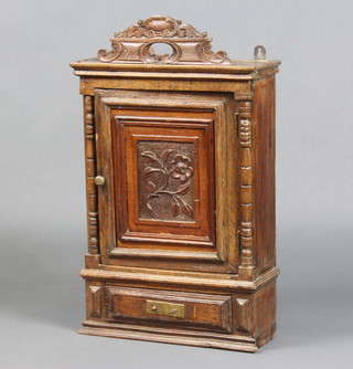 An 18th Century style Continental oak hanging cabinet with pierced panel door, the base fitted a drawer 67cm x 40cm x 15cm 