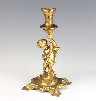 A gilt metal candlestick in the form of a cherub raised on a rococo style base 24cm x 11cm x 11cm (dent to sconce) 