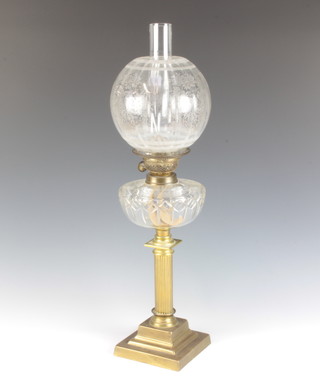 A Victorian cut glass and brass oil lamp with clear cut glass reservoir raised on a reeded brass column and stepped base with etched glass shade