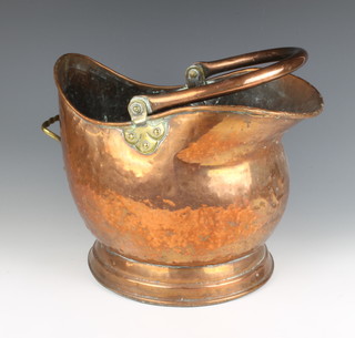 A copper and brass helmet shaped coal scuttle with swing handle (some dents) 37cm x 27cm  