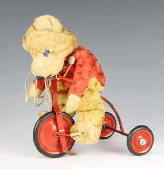 A pull along model of a bear on a tricycle 
