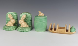 A Sylvac preserve jar in the form of a barrel the knop with a terriers head 1849 14cm, a ditto toast rack with terrier head 1990 17cm and a pair of bunny bookends 1311 12cm 