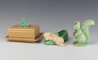 A Sylvac beige butter dish and cover the handle in the form of a terriers head 1858 17cm, a vase with a puppy lying across a slipper 31 15cm and a figure of a squirrel 539 12cm 