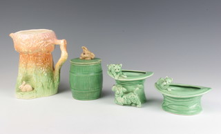 A Sylvac green vase in the form of a cat and a dog beside a giant top hat 1484 9cm, a ditto with a cat sitting on a rim of a top hat 165 12cm, a preserve pot and cover the handle in the form of a terriers head 1849 12cm and a rustic jug with a bunny 355 16cm 