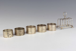 A silver 5 bar toast rack with ball feet Birmingham 1938, 5 silver napkin rings, 306 grams