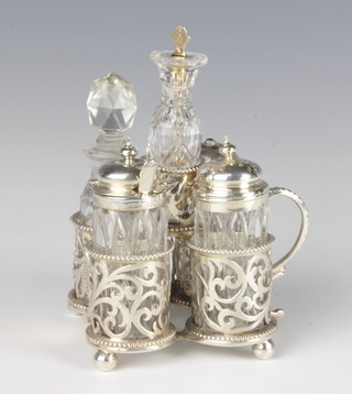 A Victorian silver 5 section cruet stand with pierced scroll decoration on ball feet, Sheffield 1874, with 5 matched condiment bottles 
