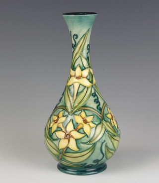 A modern Moorcroft bottle vase, the green ground decorated with daffodils with impressed and printed marks 23cm 