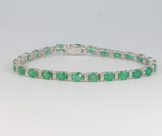 An 18ct white gold emerald and diamond line bracelet, the emeralds approx. 8.31ct, the diamonds 0.65ct, 17.5cm 