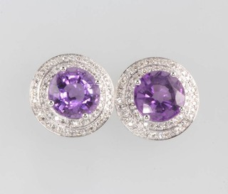A pair of 14ct white gold circular amethyst and diamond earrings, the brilliant cut amethysts approx. 5.9ct surrounded by brilliant cut diamonds 0.6ct, 15mm diam. 