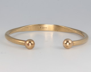 A 9ct yellow gold bangle with bead ends 21.2 grams