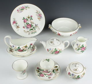 A Wedgwood Charnwood pattern tea and dinner service comprising breakfast teapot, milk jug, lidded sugar bowl, 6 tea cups, 6 saucers, 2 bowls, a sauce boat and stand, 11 small plates, 3 side plates, 7 medium plates, 5 dinner plates, 2 tureens, an oval dish, 5 dessert bowls, 1 soup bowl and a tapered vase 