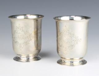 A pair of Victorian silver beakers of plain form with chased scroll cartouche and monogram, London 1869, maker RH, 10cm, 305 grams