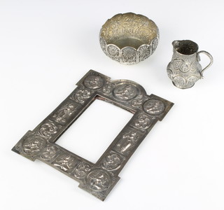 An Indian repousse silver rectangular frame decorated with deities together with a ditto cream jug and sugar bowl 230 grams