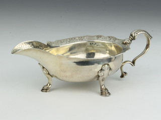 A Georgian silver Scottish sauce boat with chased decoration, scroll handle and hoof feet, rubbed marks 165 grams 